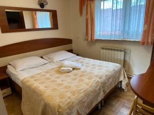 a bedroom with a bed with two towels on it at Willa Borowik in Zakopane