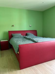 a red bed in a room with green walls at Wante 20 in Bruges