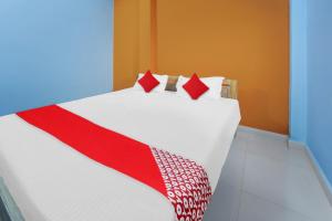 a bed with a red and white blanket on it at Flagship Youngsky in Gulzārbāgh