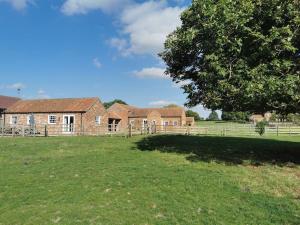 una vecchia casa di mattoni in un campo con un albero di Bainvalley Cottages - The Shamba, sleeps 4 a Lincolnshire