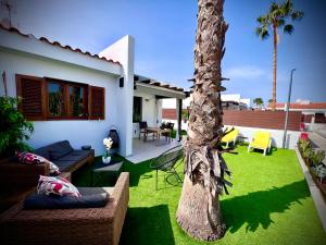 a yard with a palm tree and a house at Escarabajo Bungalow il Maggiolino in Maspalomas