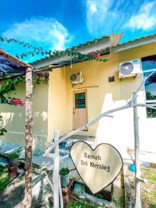 ein Haus mit einem Herzschild davor in der Unterkunft Villa Maya in Kampung Mawar