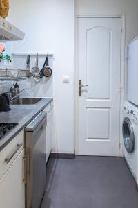 a kitchen with a sink and a white door at Le Victorieux - Appart 2 pièces -Proche Paris in Clichy