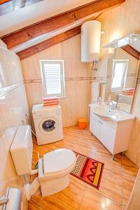 bagno con servizi igienici, lavandino e lavatrice di Apartmani Rita a Milna Altre 42 foto