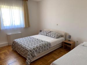 1 Schlafzimmer mit einem Bett, einem Nachttisch und 2 Betten in der Unterkunft Apartman Theresa in Barbat na Rabu