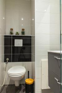 a bathroom with a white toilet and a sink at Le Victorieux - Appart 2 pièces -Proche Paris in Clichy