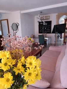 sala de estar con flores amarillas y sofá en Coty's Beach, en Benalmádena