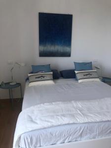 1 dormitorio con cama blanca y almohadas azules en Vista Portofino, en Zoagli