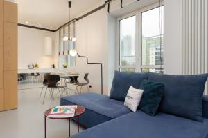a living room with a blue couch and a table at Marszałkowska 140 Apartments in the Center of Warsaw by Renters in Warsaw
