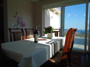 a table with a bottle of wine and a glass at Villa Soleada in Herceg-Novi