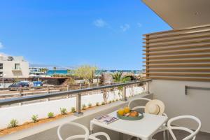 a balcony with a table and chairs and a view of the ocean at Ostrakon Suites in Agia Marina Nea Kydonias