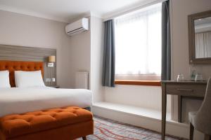 a bedroom with a bed and a window and a chair at Bournemouth West Cliff Hotel in Bournemouth