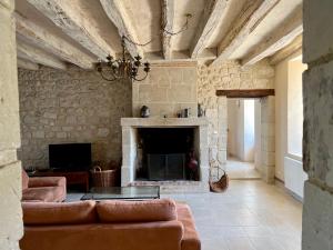 a living room with a couch and a fireplace at Villa de charme tourangelle in Vallères