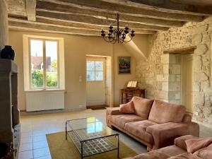 ein Wohnzimmer mit einem Sofa und einem Tisch in der Unterkunft Villa de charme tourangelle in Vallères