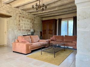 a living room with a couch and a glass table at Villa de charme tourangelle in Vallères