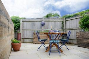 a patio with a wooden table and chairs and a fence at Jewel Pier *2 Bed House* Deal in Deal