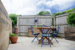 a patio with a wooden table and chairs and a fence at Jewel Pier *2 Bed House* Deal in Deal