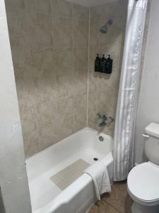 a bathroom with a white tub and a toilet at Alien Residence Inn in Pecos +13 photos