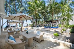a patio with tables and chairs and palm trees at InterContinental Phuket Resort, an IHG Hotel in Kamala Beach
