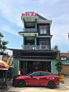 蘭珂的住宿－Nhà Nghỉ Relax Cảnh Dương，停在大楼前的红色汽车