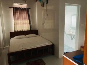 Dormitorio pequeño con cama y lavamanos en Nhà Nghỉ Relax Cảnh Dương, en Lang Co