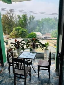 蘭珂的住宿－Nhà Nghỉ Relax Cảnh Dương，一个带桌子和两把椅子的庭院和一个阳台