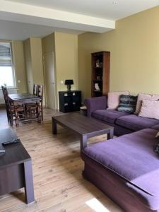 a living room with purple couches and a table at wante 22 in Bruges