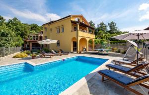 a house with a swimming pool in front of a house at Villa Ivetta in Veprinac