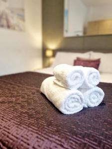 a pile of towels sitting on top of a bed at Stylish Apartment in Victorian Conversion FREE PARKING & PRIVATE PATIO Close to Beach Town Centre & BIC in Bournemouth