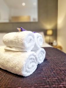 a pile of towels sitting on top of a bed at Stylish Apartment in Victorian Conversion FREE PARKING & PRIVATE PATIO Close to Beach Town Centre & BIC in Bournemouth