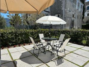 Ravello 23 Accommodation في رافيلو: طاولة وكراسي مع مظلة وطاولة