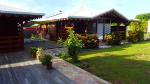 a house with a wooden deck and a yard at Bungalow charmant à Saint-François avec jardinB in Saint-François