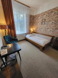 a bedroom with a bed and a brick wall at Penzion Ostravanka in Hranice