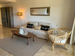 a living room with a couch and a table and a chair at New refurnished Apartment Elviria Hills Marbella in Marbella