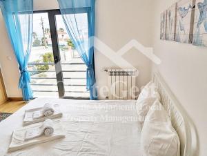 a bedroom with a white bed with blue curtains at The Lookout in Areia Branca