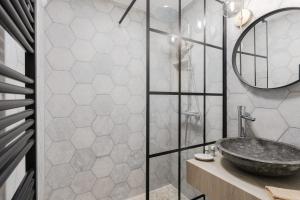 La salle de bains est pourvue d'un lavabo en pierre et d'un miroir. dans l'établissement Luxurious 4P1BR apartment renovated with taste - Deauville, à Deauville