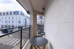 d'un balcon avec une table et une vue sur la ville. dans l'établissement Luxurious 4P1BR apartment renovated with taste - Deauville, à Deauville