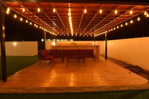 a room with a table and chairs and lights at استراحة المرجانalmarjan chalet in Ḑibāb
