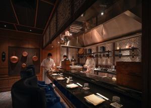 two chefs preparing food in a restaurant kitchen at InterContinental Phuket Resort by IHG in Kamala Beach