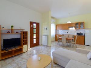 a living room with a couch and a tv and a kitchen at Apartments Belvedere in Plovanija