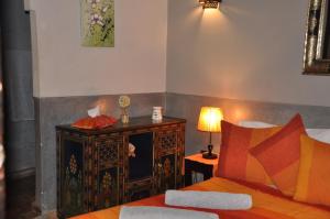 1 dormitorio con 1 cama y 1 mesa con lámpara en Riad des Etoiles, en Marrakech