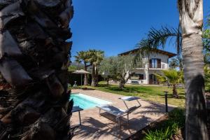 a villa with a swimming pool and a house at Casa Il Geranio in Piedimonte Etneo