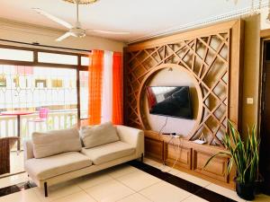 - un salon avec un canapé et une télévision dans l'établissement Lux Suites Furaha Holiday Apartments Nyali, à Mombasa