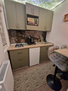 a small kitchen with green cabinets and a table at Relaxveld Nature in Curtea de Argeş