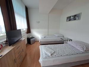 a room with two beds and a flat screen tv at Nevada in Gdynia