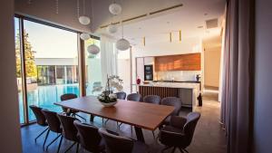 a dining room and kitchen with a table and chairs at A modern villa in Zmijavci with a gym, tennis and basketball court in Zmijavci