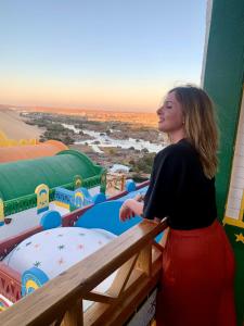 a woman standing on top of a building with a view at Kato Dool Wellness Resort in Aswan