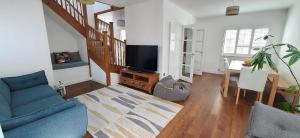 a living room with a blue couch and a television at 3-Bedroom Family Home. Just 5 Mins From The Beach! in Kent