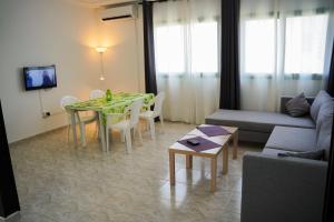 un soggiorno con tavolo e divano di Appartement confortable proche plage et centre ville a Nabeul
