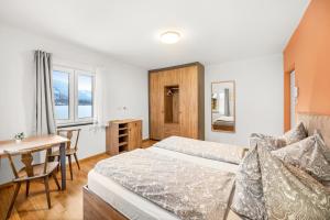 a bedroom with a bed and a table and a desk at Hallstatt Lakeside Top 1 in Hallstatt